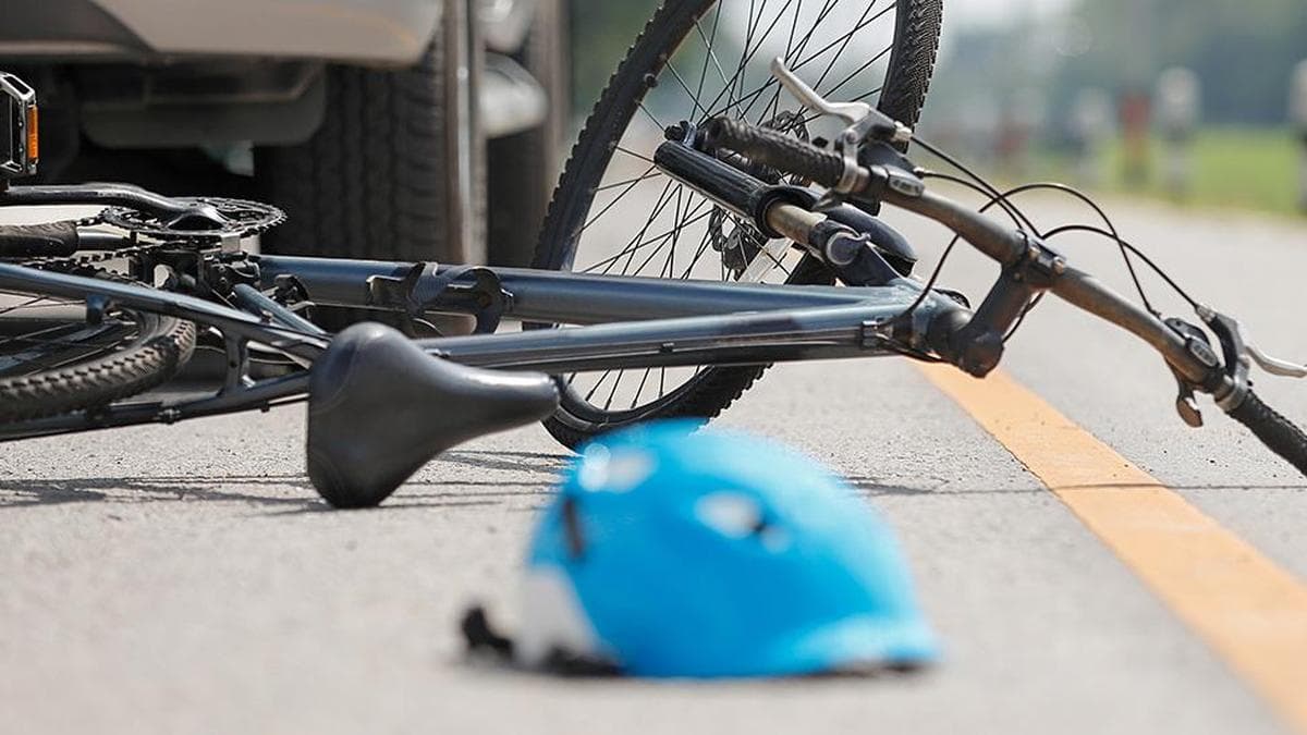 Young man drives car wearing helmet in Athani